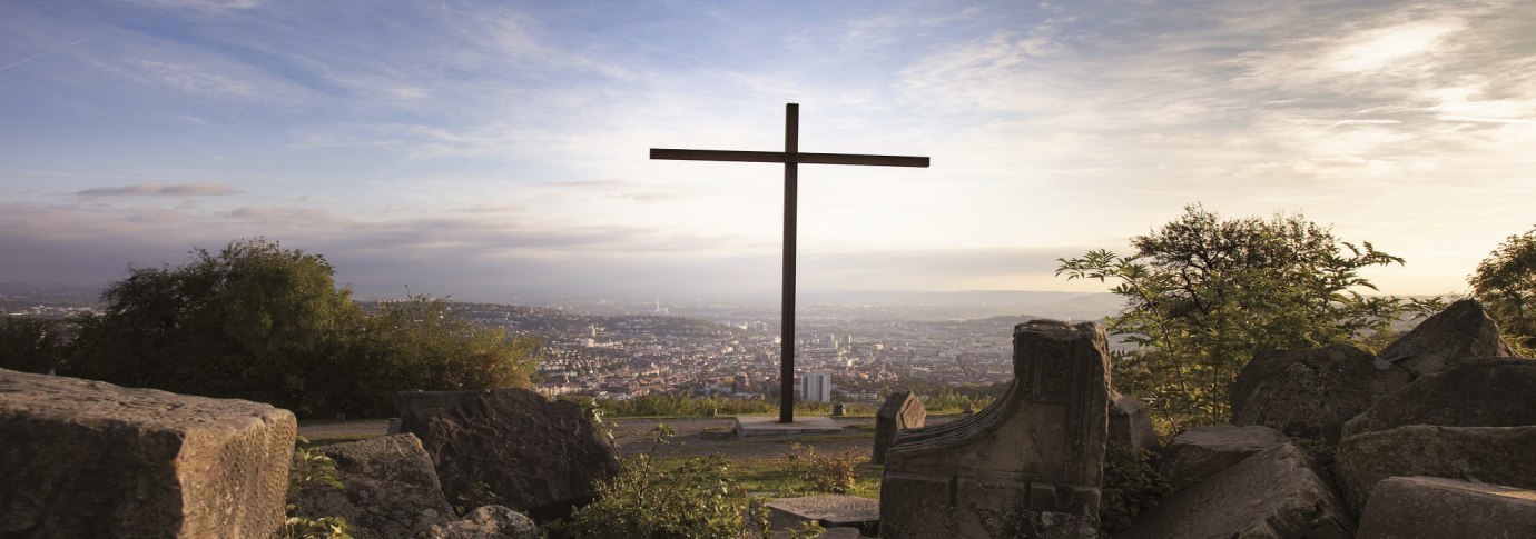 Mittig im Bild ist das große Kreuz auf dem Birkenkopf zu sehen. Im Vordergrund liegen Trümmerhaufen. Im Hintergrund hat man eine Aussicht auf Stuttgart., © Stuttgart-Marketing GmbH, Jean-Claude Winkler